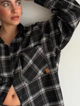 Pantalón de corte recto y holgado, confeccionado en tela de viyela con estampado de cuadros en tonos negro, gris y blanco. Presenta cintura elástica para mayor comodidad.