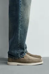 Mocasines casuales para hombre, fabricados en piel con acabado en serraje color marrón, de corte liso con detalle de bordón y suela blanca a contraste.