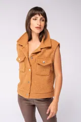 Chaleco color camel de tejido boucle, con cuello solapa, cierre frontal con botones y bolsillos de parche en el pecho.