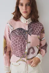 Camisa de lino con estampado artístico, cuello y puños tejidos a mano en crochet. Presenta cierre frontal con botones y un bolsillo en el pecho.