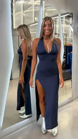 Vestido largo azul marino con escote halter profundo, espalda descubierta y tajo lateral alto.