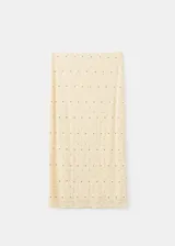 Falda midi de corte recto, confeccionada en tejido texturizado de color beige con pequeñas tachas metálicas distribuidas en el diseño y forro interior.