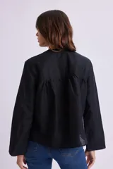 Camisa negra de lino con cuello en V y cierre frontal con botones.