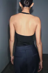 Top de cuello halter con diseño ajustado y escote con costuras tipo corset en el busto. Presenta espalda descubierta y bajo recto.