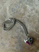 Collar corto de cadena plateada con dije de corazón tridimensional y brillante.