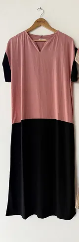 Vestido largo oversize en combinación de colores tostado y negro, con escote en V, mangas cortas y bolsillos laterales.