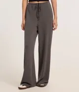 Pantalón flare negro con textura acanalada, cintura elástica con lazo y confeccionado con viscosa certificada.