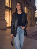 Blazer de eco cuero negro, con solapa clásica, cierre frontal con botones y bolsillos aplicados.