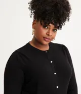 Cárdigan negro de punto con botonadura delantera, cuello redondo y puños ajustados.