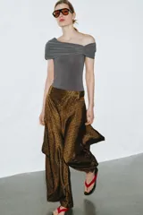 Body azul marino de escote asimétrico con un hombro descubierto, detalle de frunces en el busto y cierre de botones a presión en la parte inferior.