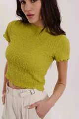 Blusa color verde lima con textura arrugada y mangas cortas.