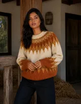 Buzo de lana merino con diseño de inspiración nórdica y cuello redondo. Presenta un patrón geométrico en tonos crudo, camel y terracota, con puños y ruedo acanalados.