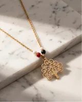 Collar de acero dorado con diseño de tres cadenas finas. El dije central representa un árbol de la vida calado, decorado con pequeñas cuentas de perla, ónix negro y cristal rojo.