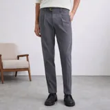 Pantalón de corte relaxed fit confeccionado en algodón con spandex, presenta pinzas frontales, cierre de botón y bolsillos laterales.