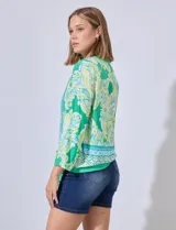 Blusa estampada con escote en V, abertura central con botones y terminación anudada. Largo de manga regulable con presilla y botón.