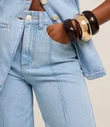 Pantalón wide leg de cintura alta, confeccionado en jeans celeste, con trabillas en la cintura, cierre tradicional, bolsillos y recortes delanteros de frisos.