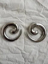 Aros grandes plateados con forma de espiral.