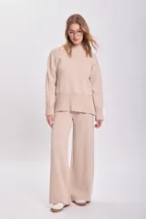 Pantalón de punto en color beige, de corte recto y tiro alto, con cintura elástica y diseño holgado.