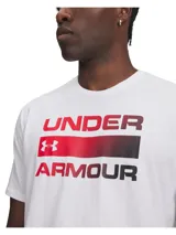 Remera Under Armour de manga corta en color blanco, con cuello redondo y estampado gráfico frontal de la marca con efecto degradado en tonos rojo y negro.