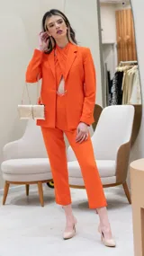 Mono color naranja con escote cruzado, sin mangas y pantalón de corte recto. Incluye blazer haciendo juego.