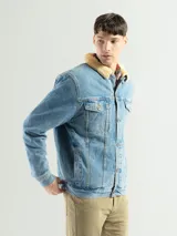 Campera de jean celeste con cuello de corderito color crema, cierre con botones metálicos, bolsillos frontales con solapa y puños abotonados.
