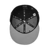 Gorra de béisbol de visera plana, colaboración entre Corteiz y New Era. Presenta un diseño bicolor en negro y gris con el logo de Corteiz bordado en el frente y el logo de New Era en el lateral.
