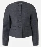 Blazer de sastrería color gris con estampado de cuadros, cuello redondo y cierre frontal con botones forrados. Presenta mangas largas con volumen tipo baloné y bolsillos frontales con solapa.