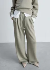 Pantalón wide leg de tiro medio con cintura elástica y cordón ajustable. Presenta diseño con pinzas frontales, bolsillos laterales y corte holgado.