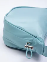 Riñonera semicircular color celeste de nylon con correa regulable, cierre superior y elásticos en los laterales.