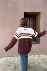 Saco tejido de punto con diseño de ochos, con bloques de color en marrón, blanco, rojo y amarillo neón. Presenta mangas largas y cierre frontal con botones.