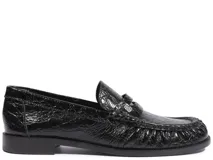 Mocasín Schutz de cuero negro con textura efecto cocodrilo, diseño clásico con antifaz y suela plana.