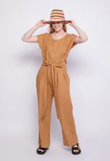 Mono color verde oliva de lino y viscosa, con botones veteados, manga corta, dos bolsillos laterales y lazo para atar a la cintura.