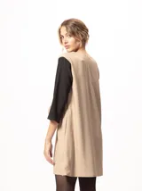 Vestido corto negro con mangas 3/4 verdes, cuello bote y bolsillos laterales.