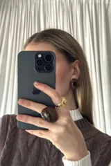 Anillo grande color marrón oscuro con diseño ovalado y efecto acrílico brillante.