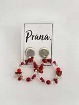 Par de aros colgantes con base plateada y diseño circular con cuentas rojas, plateadas y transparentes.