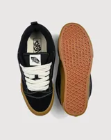 Championes Vans modelo Knu Skool, de estética inspirada en los años 90 con silueta voluminosa. Confeccionados en gamuza negra, presentan lengüeta y cuello acolchados, Sidestripe en diseño 3D y suela de goma color caramelo con patrón waffle.