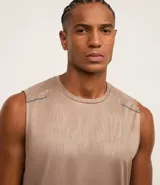 Musculosa deportiva masculina color beige, con cuello redondo y estampado sutil de líneas. Presenta recortes en los hombros y está confeccionada con tecnología Dry para mayor transpirabilidad.