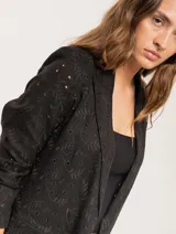 Blazer negro con bordado floral, de corte recto y largo a la cadera.