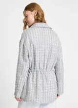 Parca gris de malla con bordado de lentejuelas, corte ajustado, cuello camisero, cierre frontal con botones, dos bolsillos decorativos, cintura con cordón, mangas largas y largo extra.