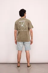 Remera verde militar de corte oversize con cuello redondo y estampado en la espalda con el logo de Brixton, una flor de hibisco y la frase "Where hibiscus grows, peace flows".