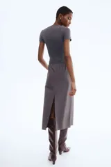 Body de microfibra color gris oscuro, con escote redondo y mangas cortas. Presenta un corte alto en la parte inferior con cierre de broches a presión ocultos en la entrepierna.