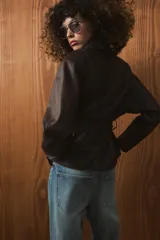 Chaqueta de Zara Woman Collection confeccionada en tejido efecto piel con textura granulada. Presenta cuello solapa, manga larga y cierre frontal con cinturón ajustable mediante lazada. Incluye forro interior.