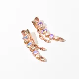 Aros colgantes con base dorada y múltiples cristales facetados en tonos rosados, lilas y champagne.