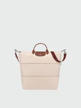 Bolso de viaje ampliable Longchamp de la línea Le Pliage Original, color marrón caqui con detalles en cuero marrón y herrajes metálicos plateados. Cuenta con asas de mano y correa de hombro ajustable y extraíble.