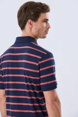 Remera polo de manga corta con diseño de rayas horizontales en color azul marino y rosado. Cuenta con cuello camisero, cierre frontal con botones y calce clásico.