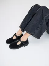 Zapatos tipo guillermina de cuero gamuza negro, con detalle de pespuntes en hilo blanco, cierre con hebilla y suela de goma con plataforma.