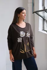 Remera de algodón color chocolate con cuello redondo, mangas largas y estampa frontal de flores en tonos plateado y dorado.
