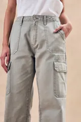 Pantalón cargo color verde oliva, de corte recto y tiro bajo, con bolsillos laterales con solapa y bolsillos delanteros diagonales.