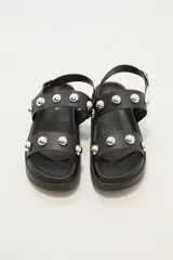 Sandalias negras con plataforma y dos tiras horizontales con apliques de tachas plateadas.