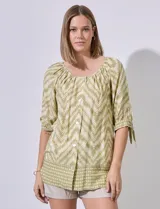 Blusa estampada con cuello redondo y abertura central con botones. Manga corta con lazo.